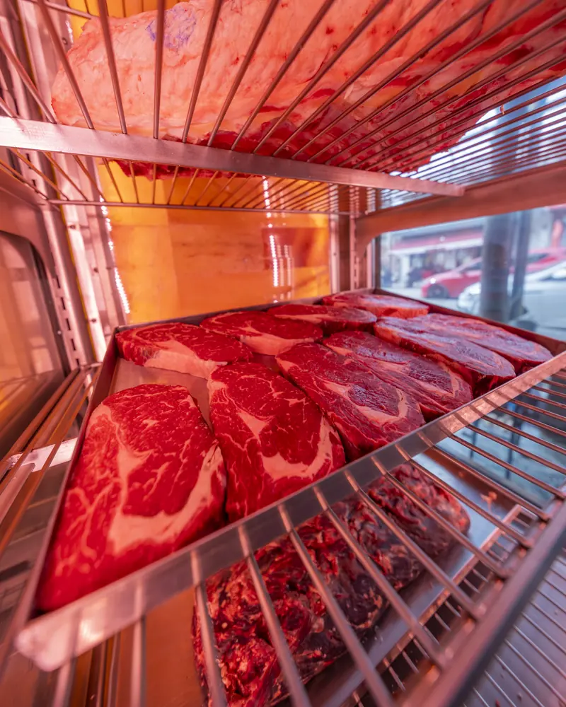 Dinlendirme dolabının raflarında steak dilimleri